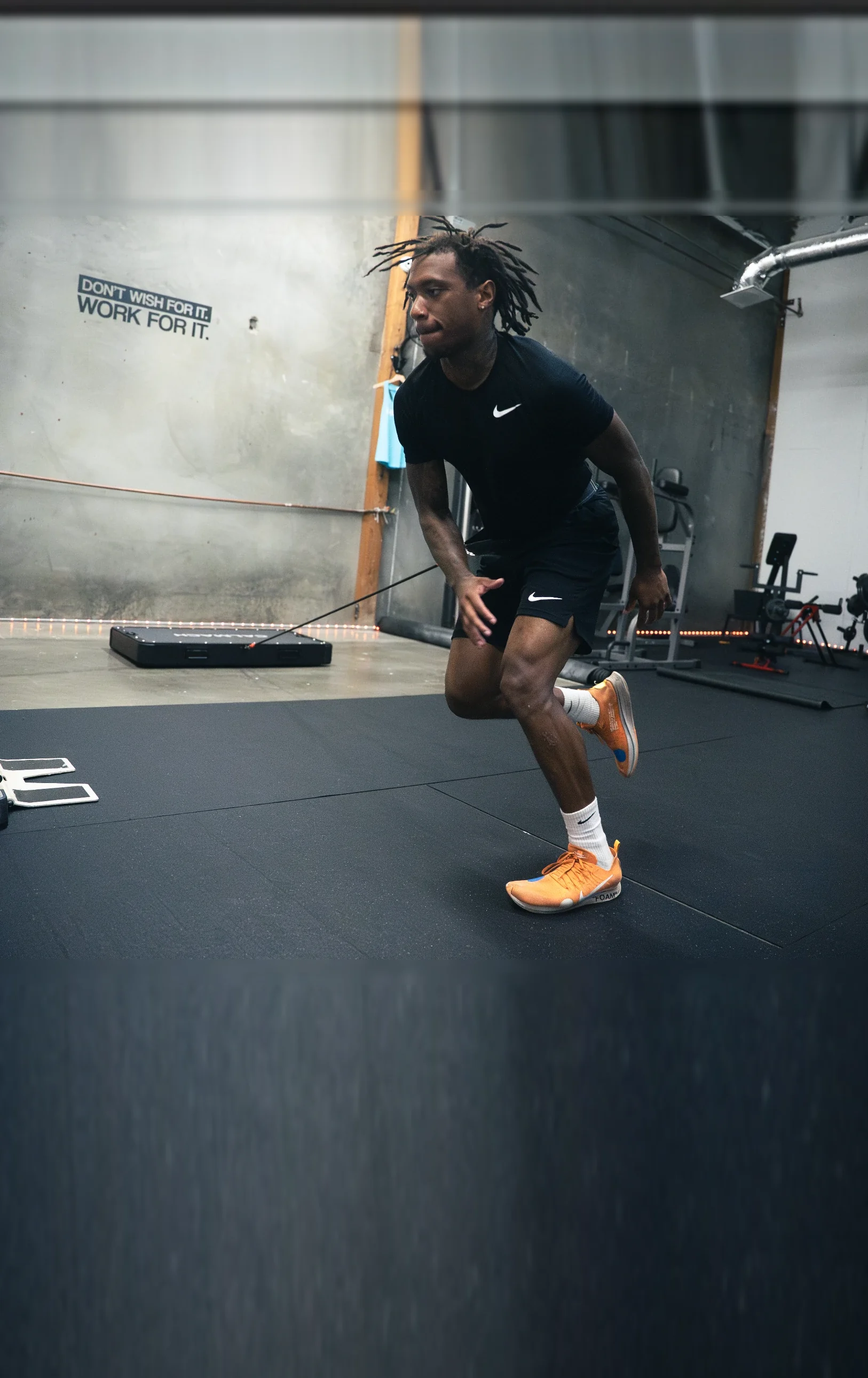 Athlete sprinting against a Calmach resistance band anchored to the platform