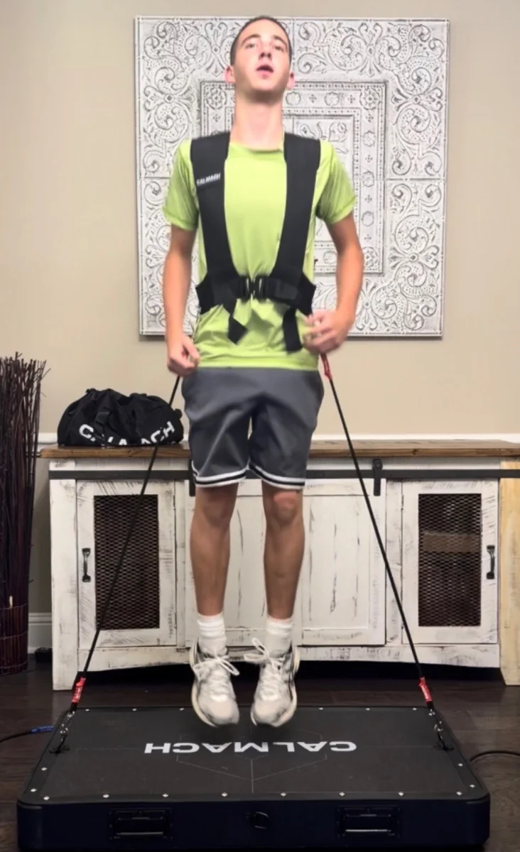 Athlete in a Calmach vest jumping on the platform at home