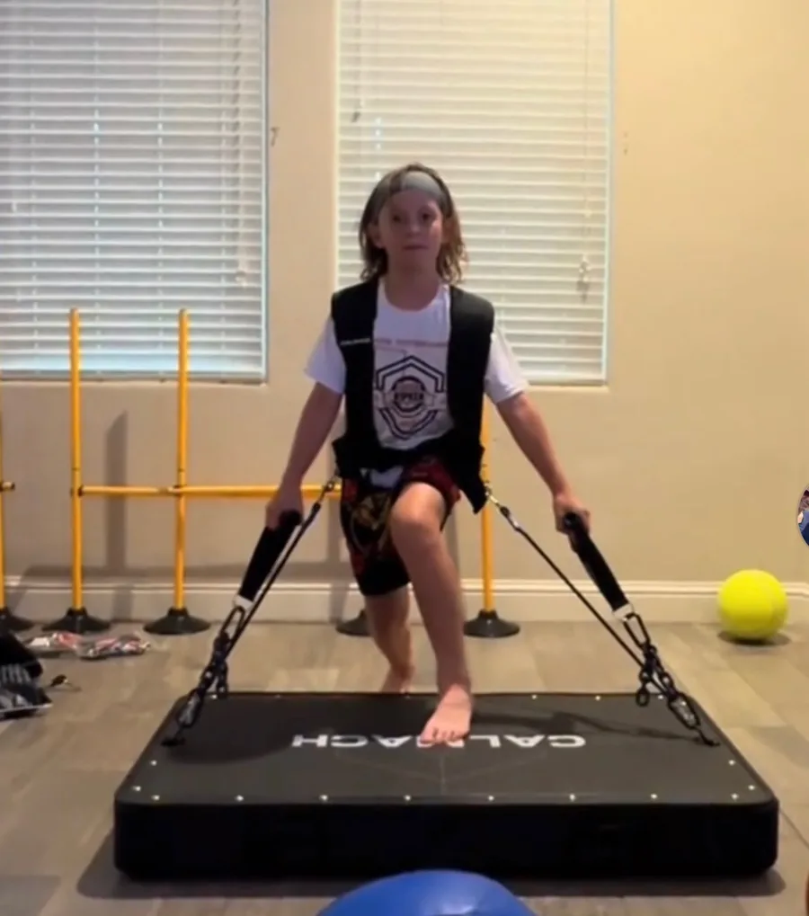 Young athlete training on the Calmach platform with the vest and handles